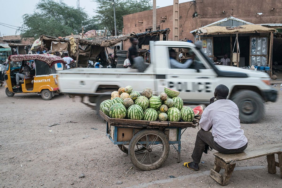 A police truck passes through a busy intersection in Agadez at dusk. Image by Nichole Sobecki. Niger, 2017.