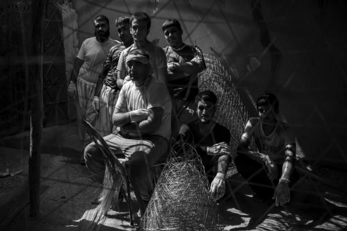 Afghan refugees posing for a portrait in the steel net-fishing factory where they work. Bushehr Port. Image by Ako Salemi. Iran, 2016.