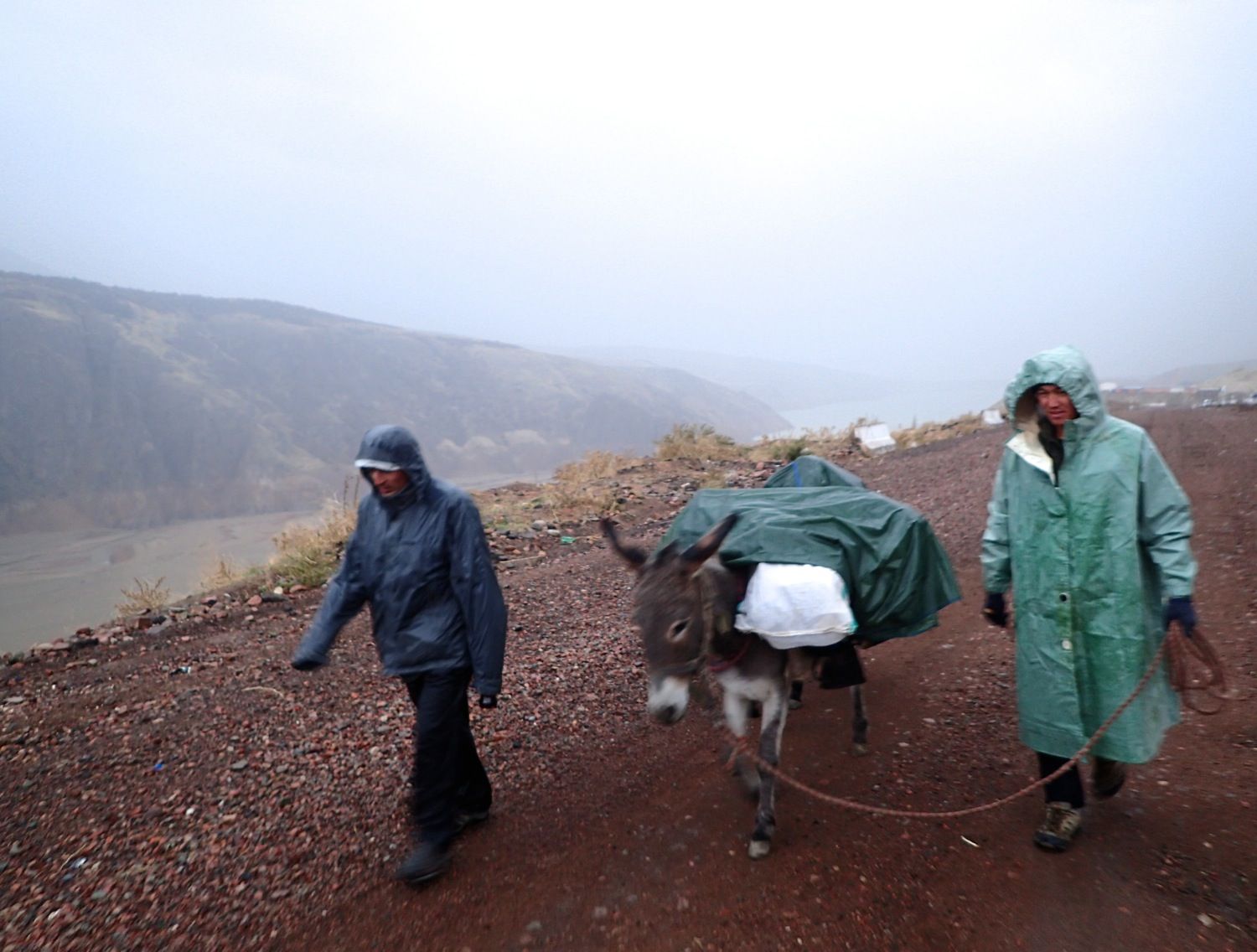 Paul Salopek's guides walk through a wet and cold Uzbek mountain region.