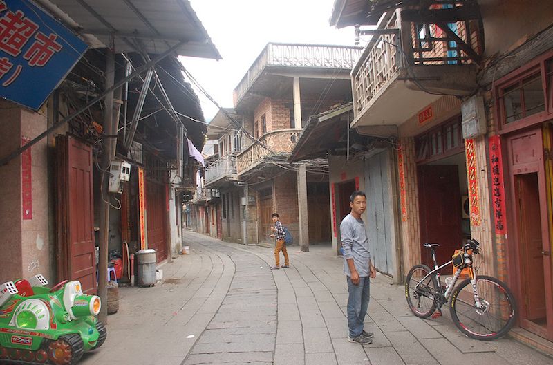 Two men stand in an empty market street.