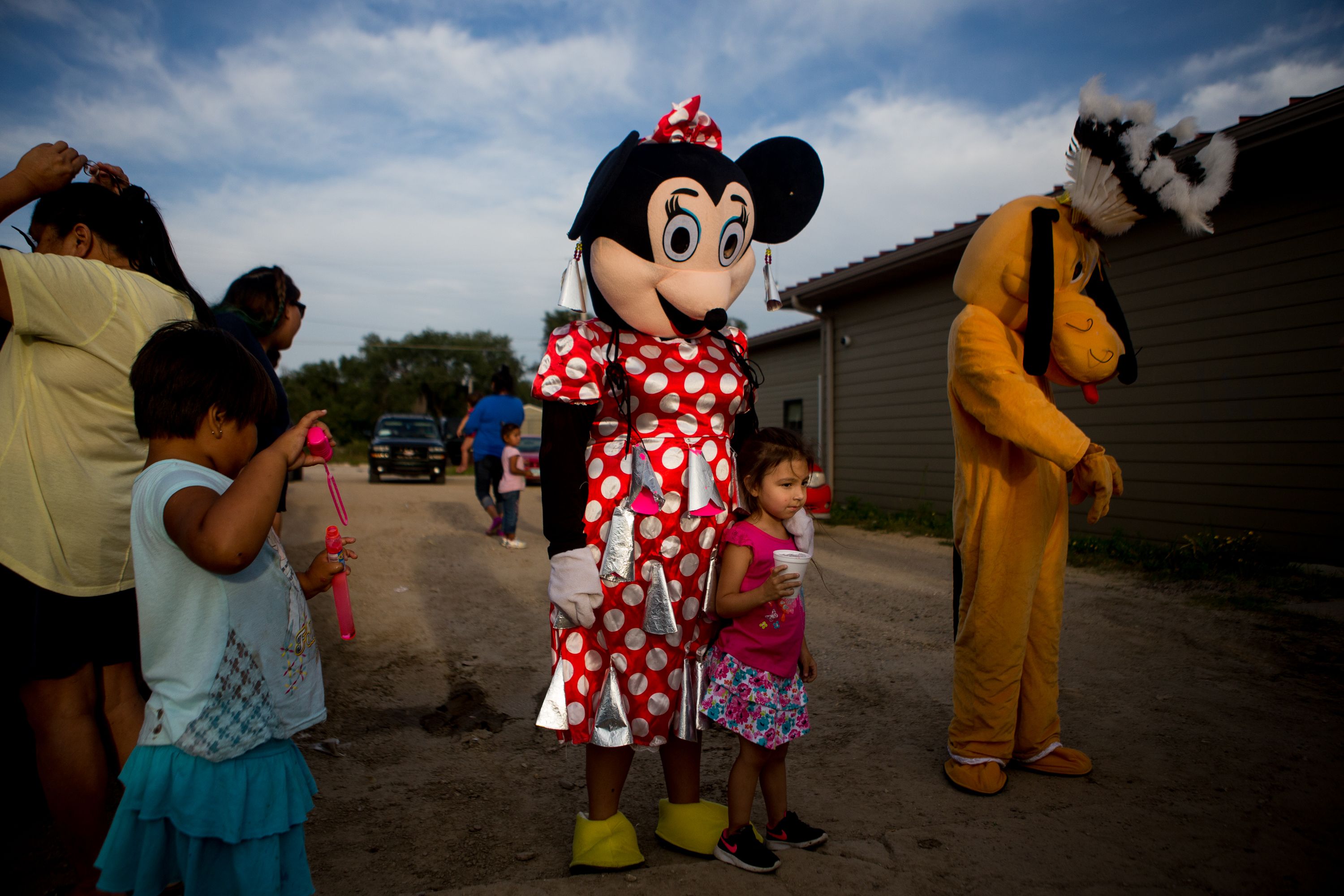  Ella Davis, 4, poses with a "Minnie Mouse" adorned with makeshift jingle bells on September 1, 2018, during the first annual Sicangu Youth Program "Back-to-School" block party in Mission, South Dakota. Image by Brian Munoz. South Dakota, 2018.
