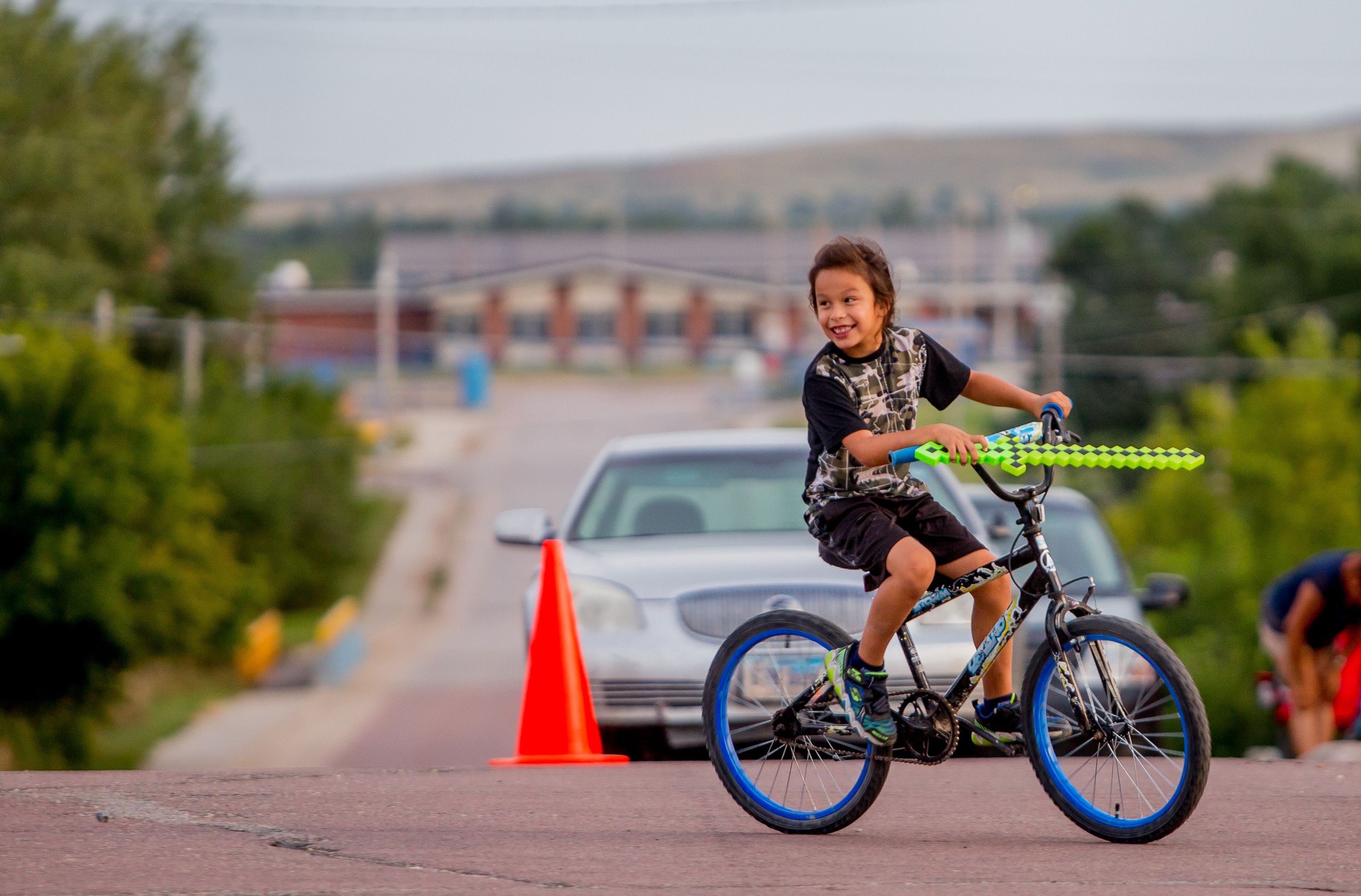 Caleb Prue, 7, of Okreek, rides his bike while playing with friends on September 1, 2018, during the first annual Sicangu Youth Program "Back-to-School" block party in downtown Mission, South Dakota. Image by Brian Munoz. South Dakota, 2018.