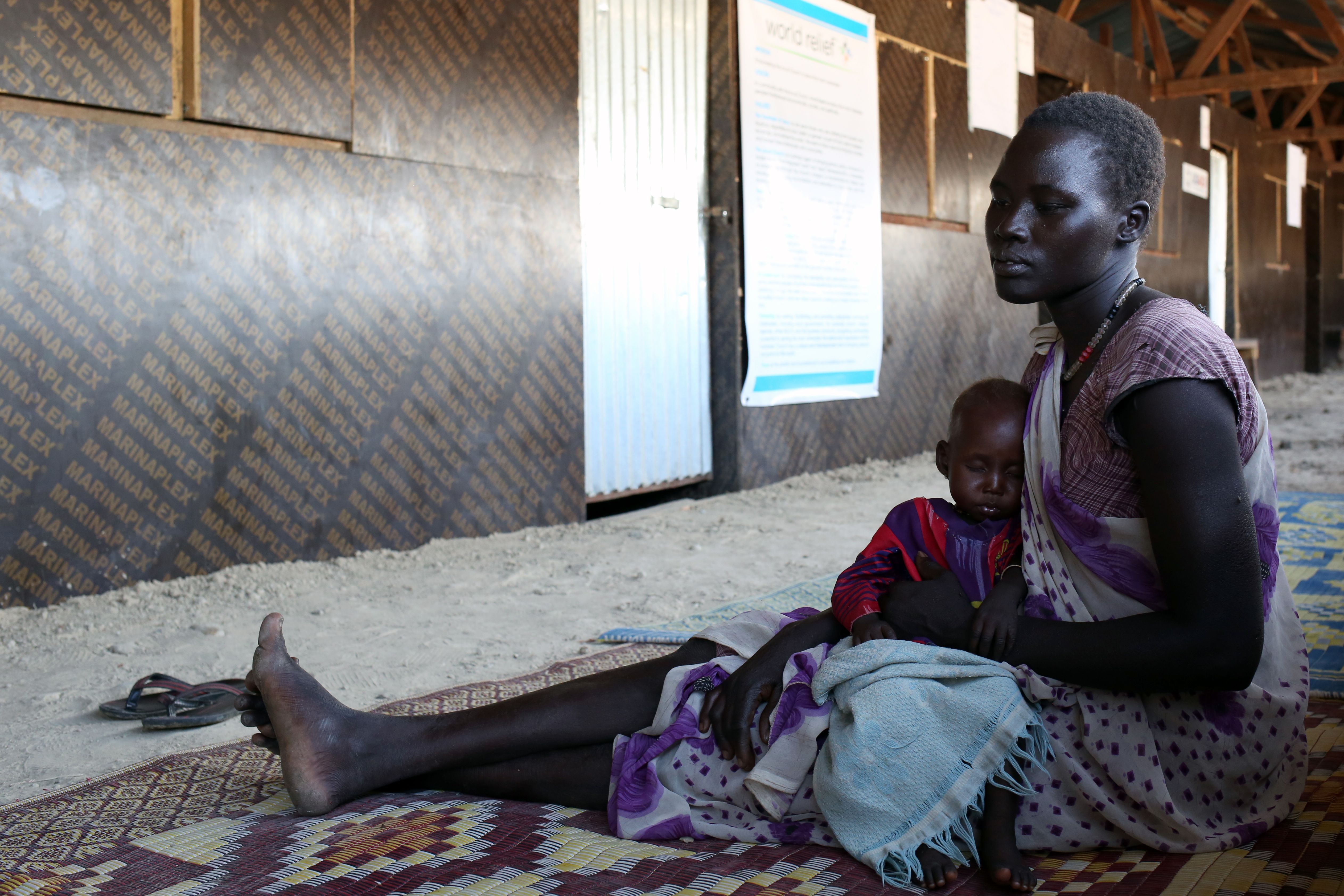 Nyabany and her daughter wait at a clinic at the U.N. base in Bentiu, South Sudan, on Dec. 18, 2016. Eight-month-old Nyadholi is suffering from severe acute malnutrition. Image by Cassandra Vinograd. South Sudan, 2016.