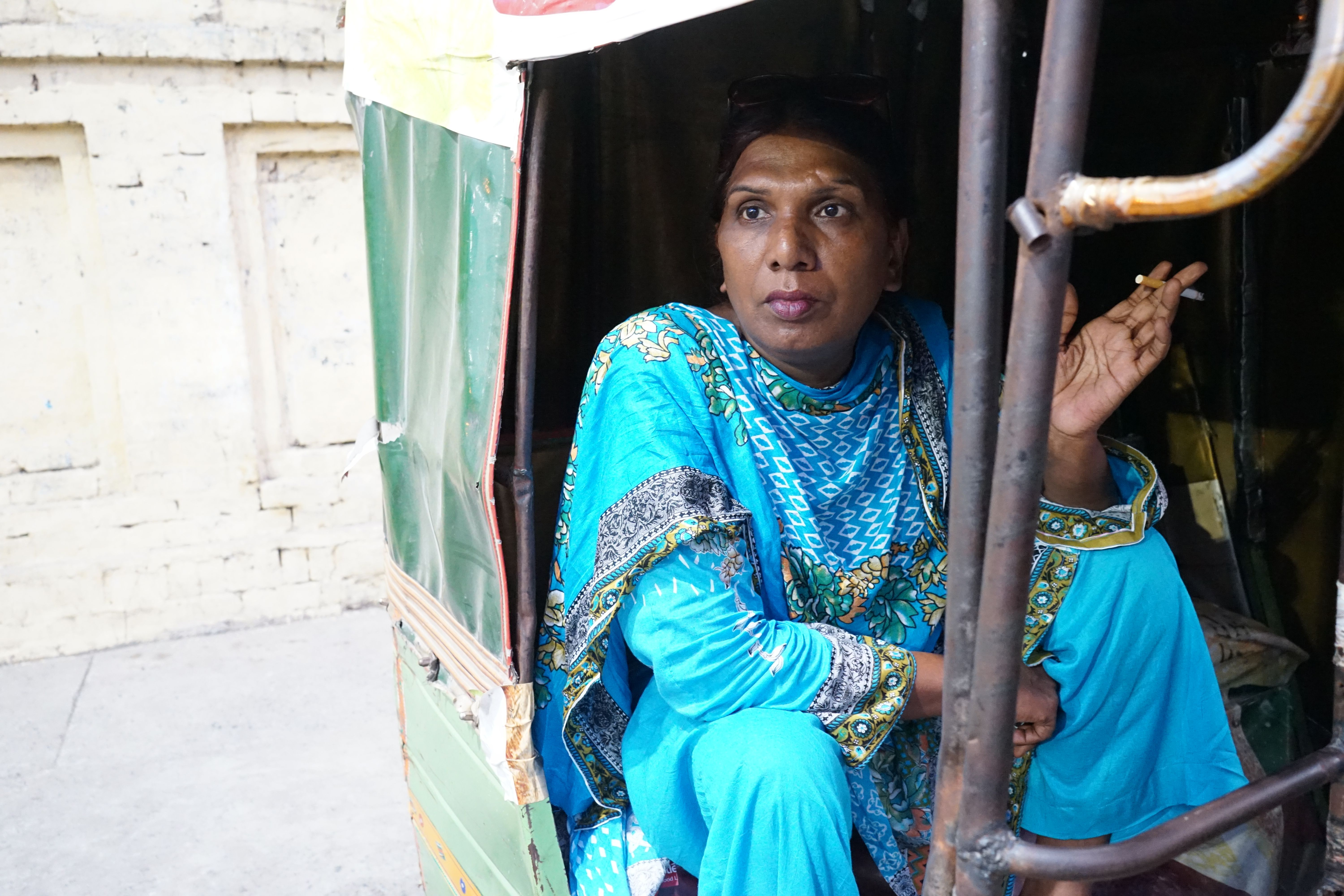 Ashi Jaan, age 45, takes a break from the protest to sit and smoke a cigarette while chatting with the rickshaw driver. Image by Ikra Javed. Pakistan, 2016.