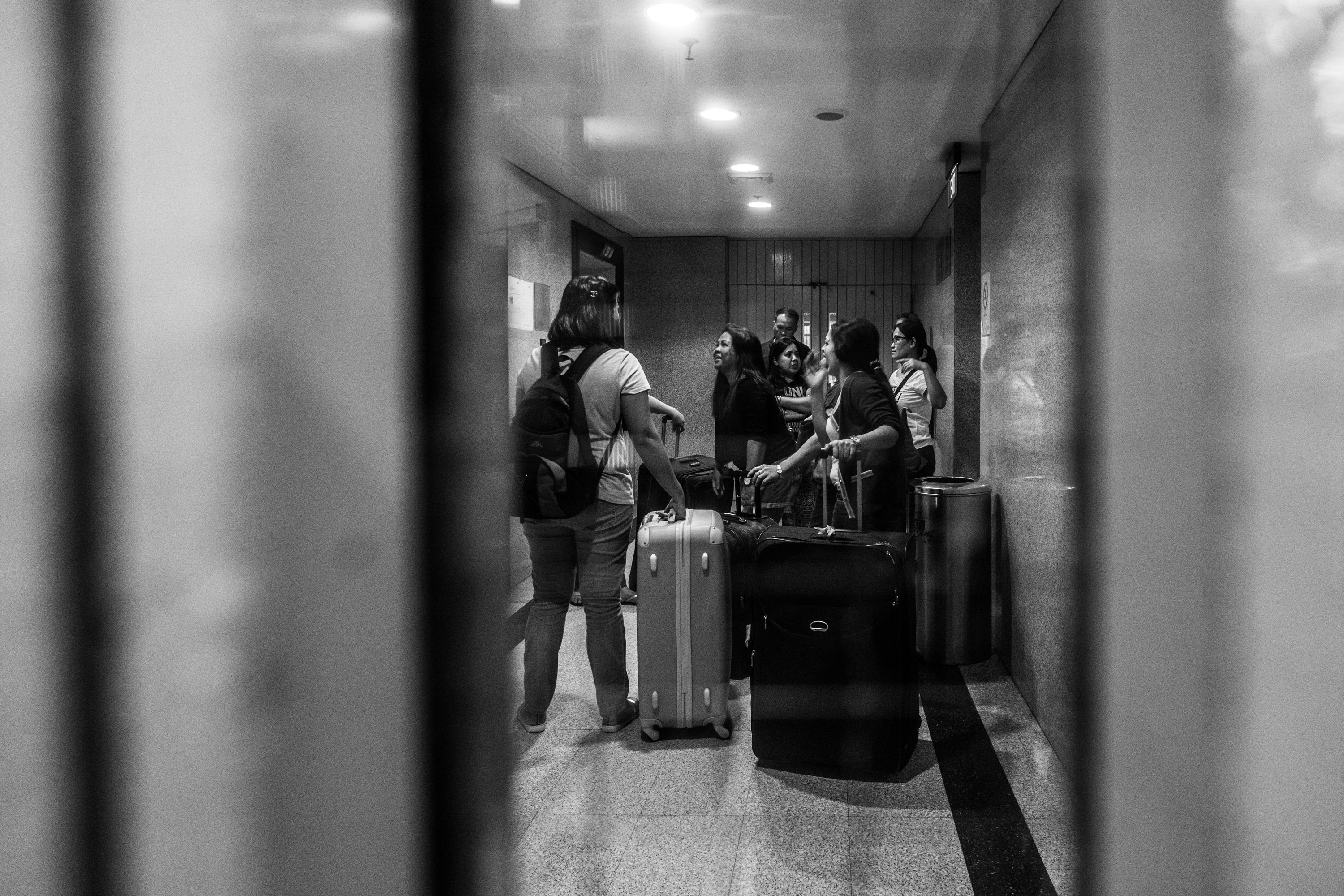 Runaway migrants helped Judy with her luggage inside Far East Shopping Center, where her agency is located. The center is filled with employment agencies. Image by Xyza Bacani. Singapore, 2016.