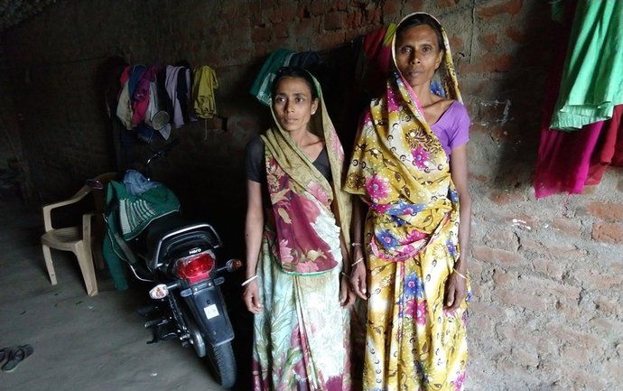 Two women attacked in a witch hunt, Madhuben and Susilaben, stand in an alley ​in Dahod District, Gujarat, India. Image by Seema Yasmin. India, 2017.