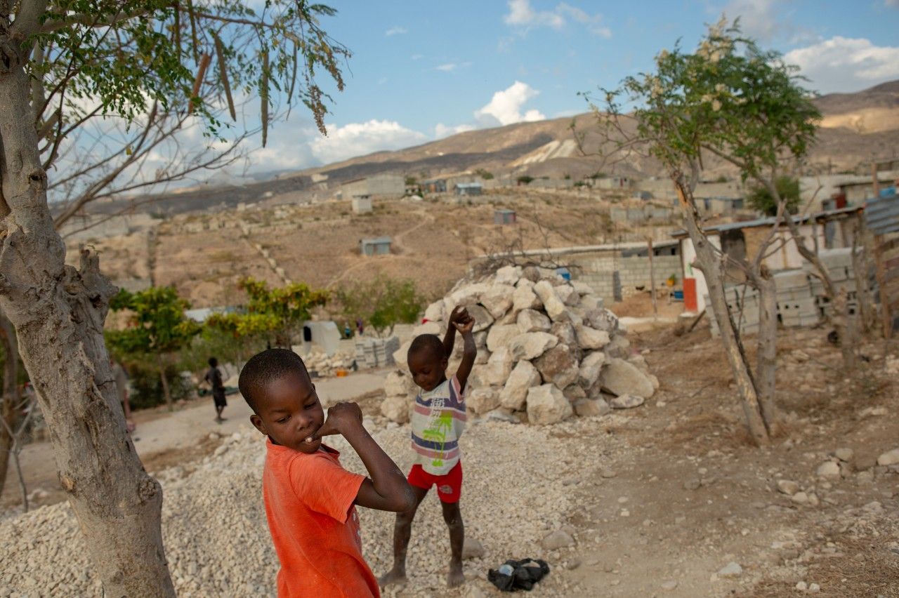 Boys play near their homes along a ridge overlooking the sea in the Village du Pecheur neighborhood of greater Canaan, Haiti. Image by Allison Shelley. Haiti, 2019.