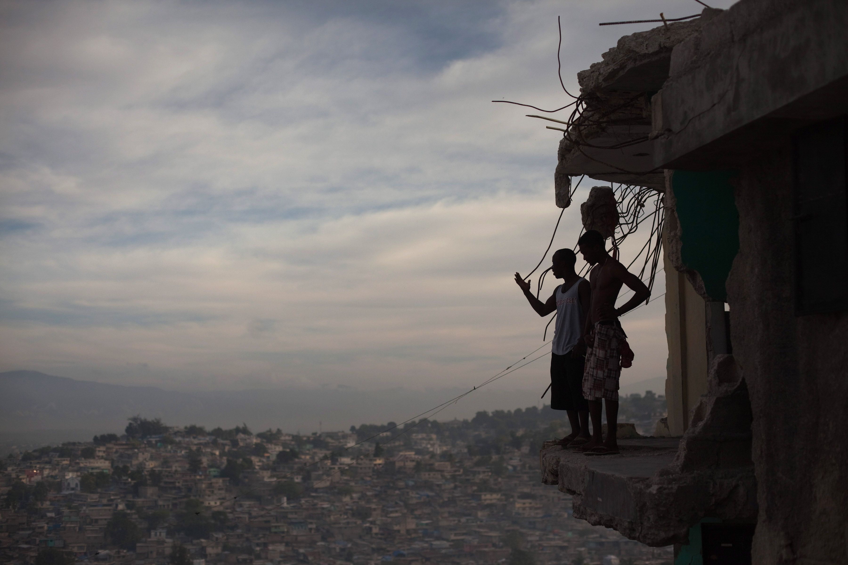 Horlich Florestal (left), 24, and Rosemond Altidon, 22, stand on the edge of their apartment building in Fort National January 9, 2011. Half the building was destroyed in the earthquake, killing many of their neighbors, including two cousins and an aunt. Image Allison Shelley. Haiti, 2011.