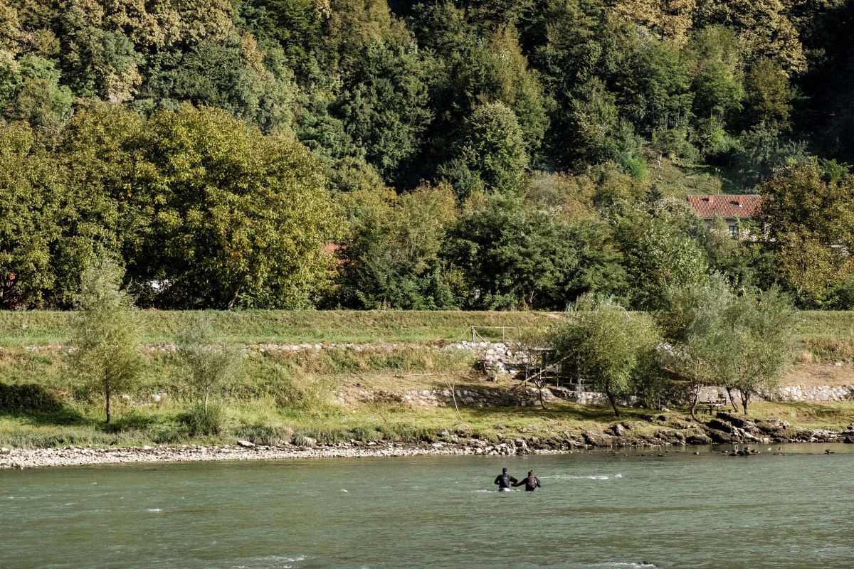 Zvornik, Bosnia-Hercegovina: Two migrants are seen crossing the river Drina between Bosnia and Serbia. As the winter is coming Drina is becoming increasingly dangerous to cross, yet it is still the most common way for the people on the move to cross from Serbia to Bosnia. Image by Ziyah Gafic. Bosnia-Herzegovina, 2020.
