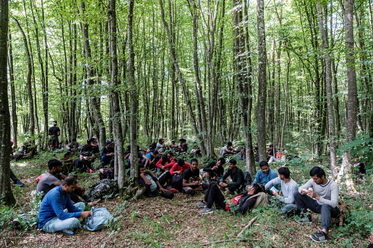 šturlić, Bosnia - Herzegovina: A group of Pakistanis are taking a break in a forest half a mile away from the border with Croatia. Once they cross the border they have nearly 200 miles to reach Italy. They move usually at night, staying away from the villages and towns. If caught they are usually stripped of all their earthly possessions and send back to Bosnia. This ilegal practice is called pushback and often includes violence, beatings and various forms of humiliation. Image by Ziyah Gafic. Bosnia-Herzegovina, 2020.

