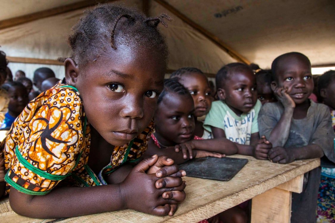 Children are taught in a makeshift classroom at a camp in Kaga Bandoro that provides refuge for thousands of Central African families displaced by conflict. Image by Jack Losh. Central African Republic, 2019.