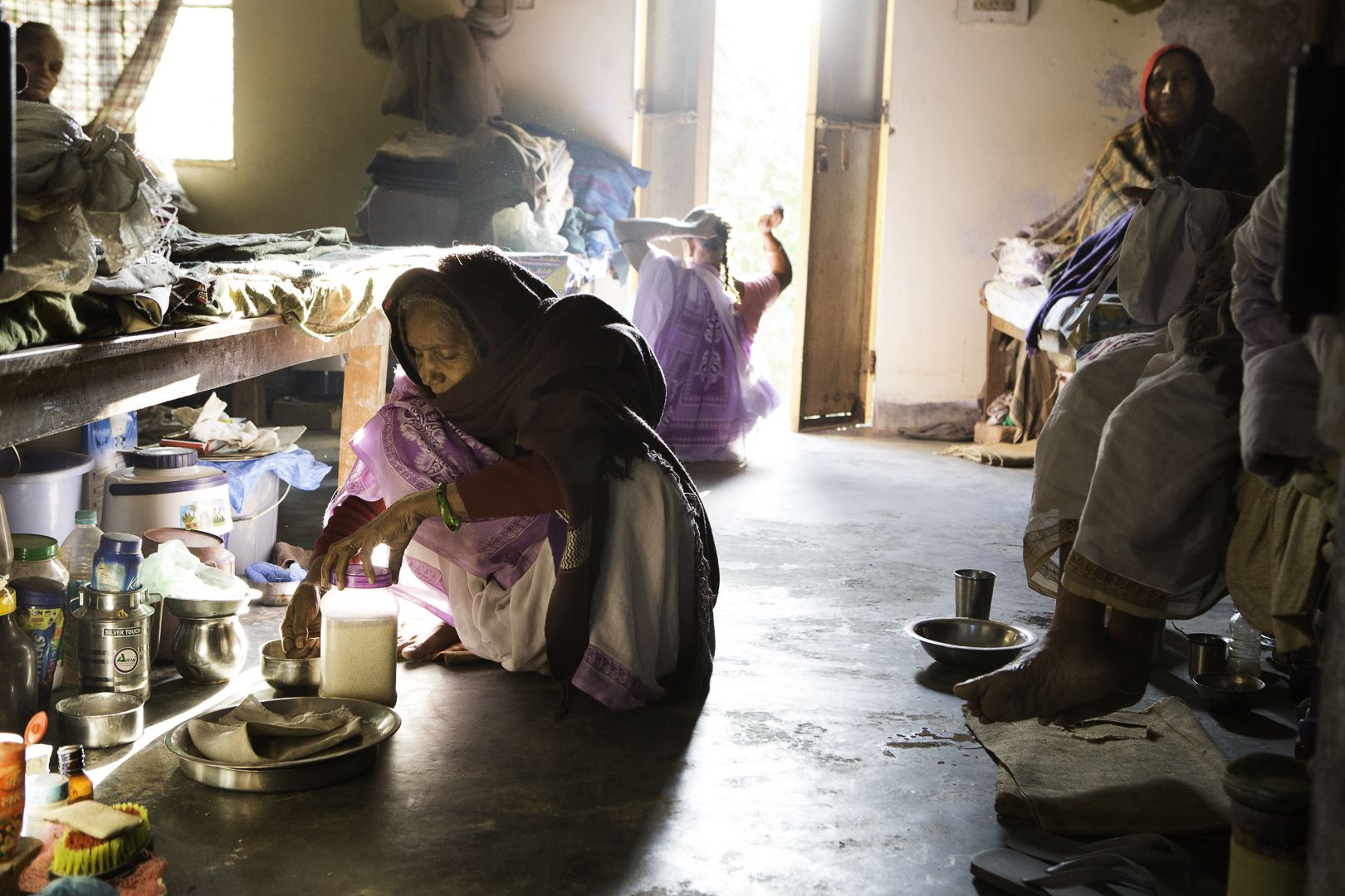 Elderly widows cook next to their beds at Tarash Mandir, a short-stay home for young women