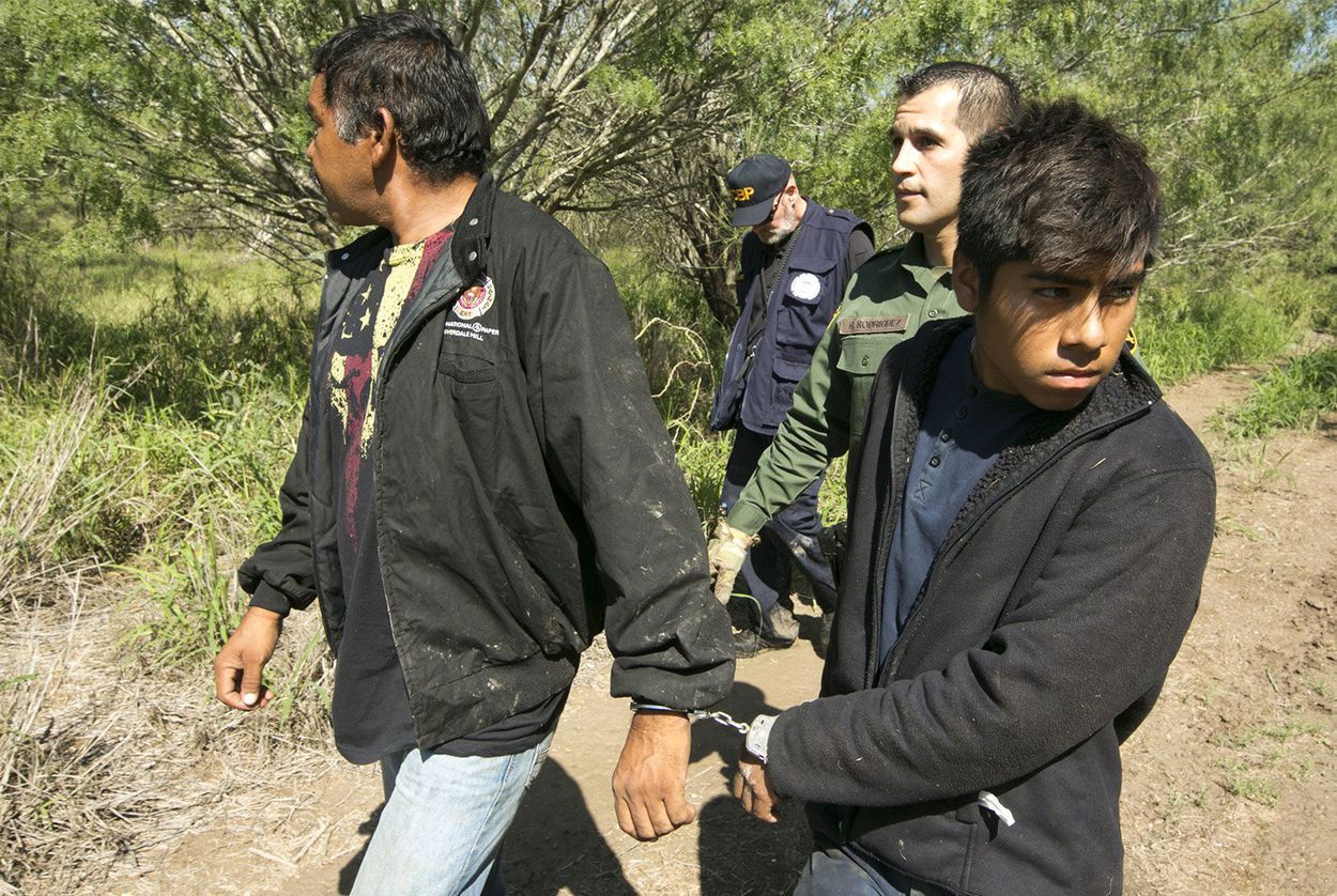 Border Patrol Agent Roberto Rodriguez escorts two Mexican nationals apprehended near the Texas-Mexico border on Oct. 12, 2017. Image by Marjorie Kamyd. United States, 2017.