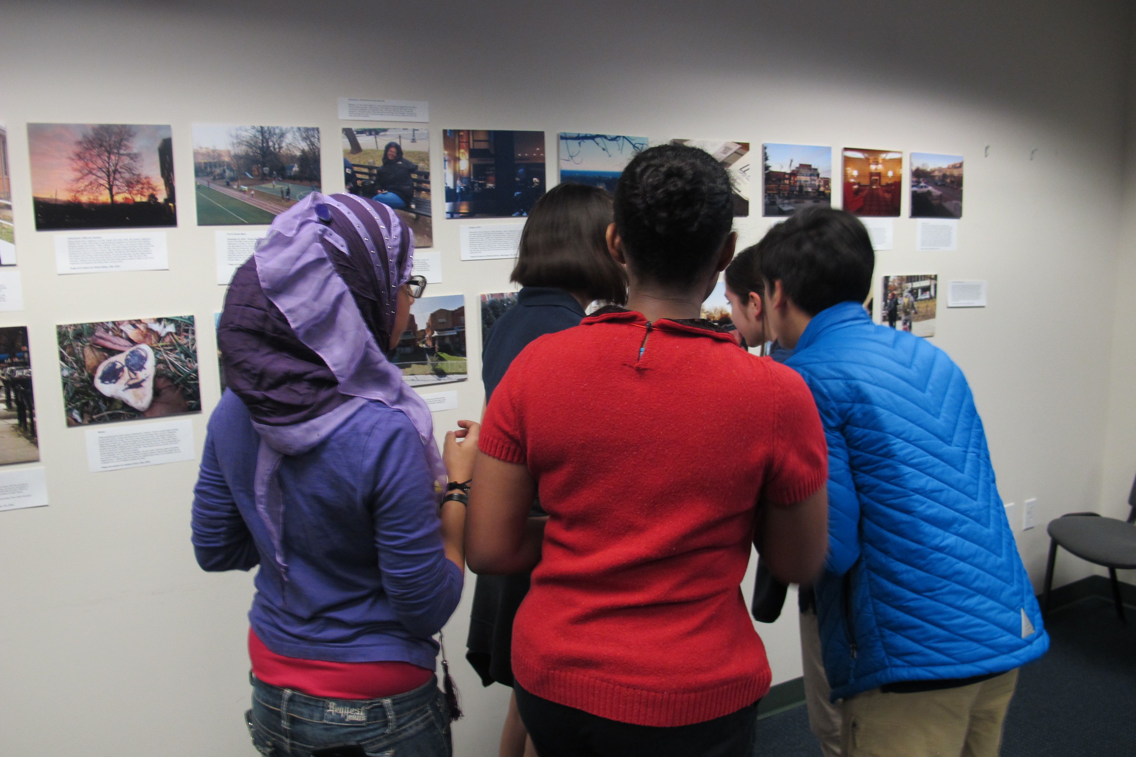 Hardy Middle School students critique one another's work at a reception hosted by the Pulitzer Center. The reception wrapped up a 3-day "Walk Like a Journalist" workshop where students practiced slow reporting, followed in the footsteps of Paul Salopek's "Out of Eden Walk". Image by Perinne Punwani. Washington, D.C., 2017. 