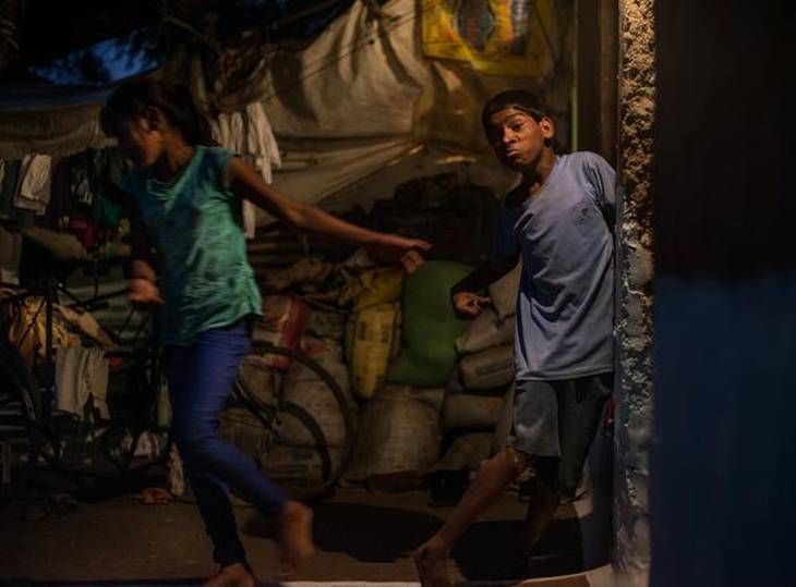 Shakey lives: Suraj Malam, 21, has cerebral palsy. He struggles to stand on his feet after losing his sister's grip as she runs from him. Image by Rohit Jain. India, 2018. 