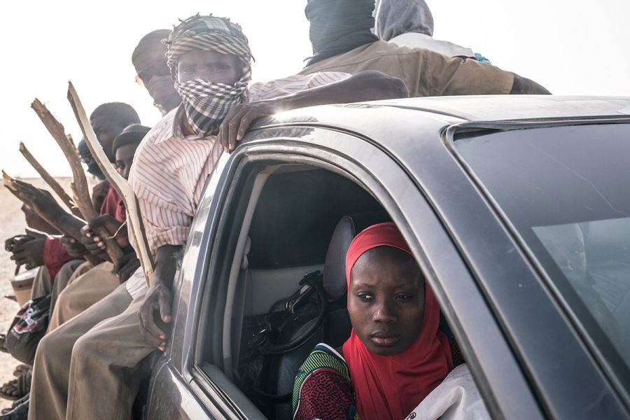 Migrants prepare to make the dangerous three-day journey from Agadez to Libya in the bed of a Toyota pickup truck. Image by Nichole Sobecki. Niger, 2017.