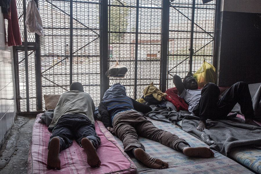 Migrants from Senegal look out into the prison courtyard from their overcrowded jail cell in the Abu Salim detention center. Image by Peter Tinti. Libya, 2017.
