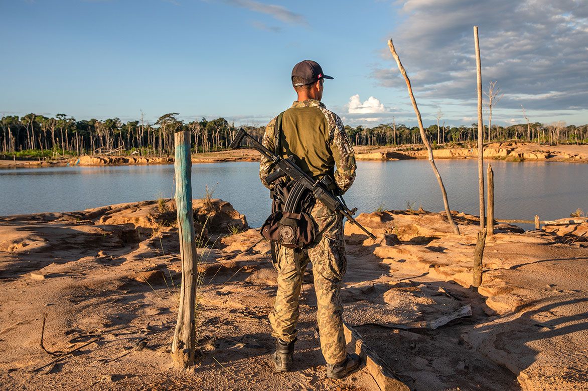 A soldier patrols La Pampa, an area in Peru that was once lush rainforest. Image by Brett Gundlock. Peru, 2019.