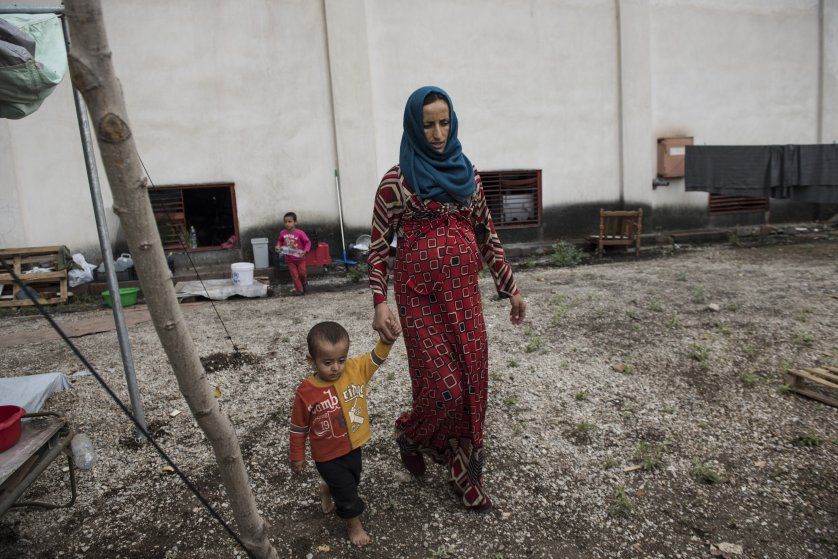 Illham Alarabi, pregnant with her fifth son, walks outside the Oreokastro camp. Image by Lynsey Addario. Greece, 2016.