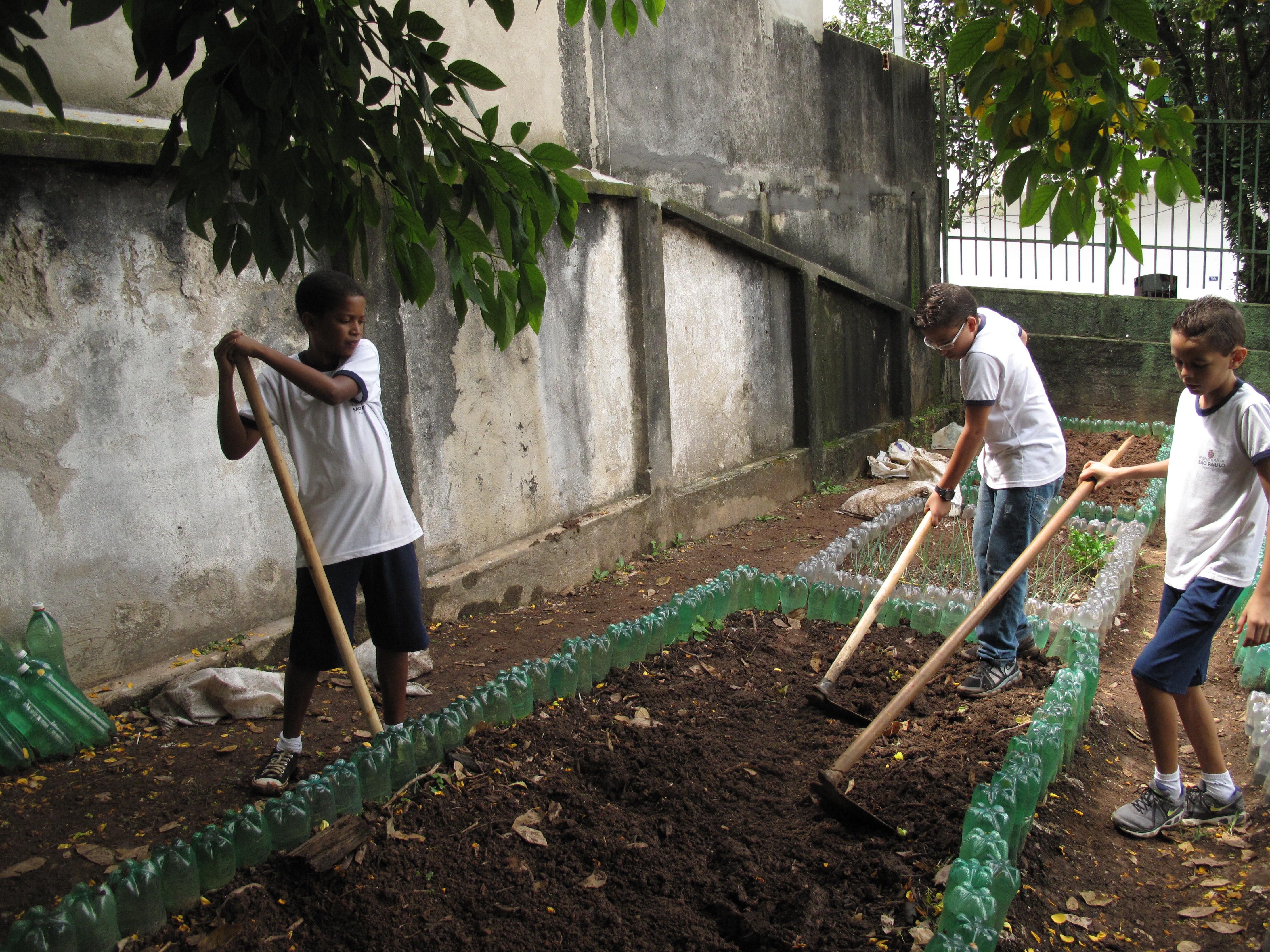Students at the Leão Machado school dig plots before mixing in compost with the soil. Rhitu Chatterjee. Brazil, 2015. 