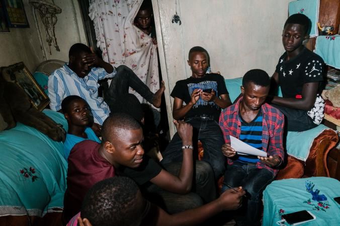Young LGBTQ people gather in the living room of the Children of the Sun safe house. At the time this photo was taken, there were eight people sleeping in the two-room apartment, though the number fluctuates daily from six to 12. Image by Jake Naughton. Uganda, 2017.
