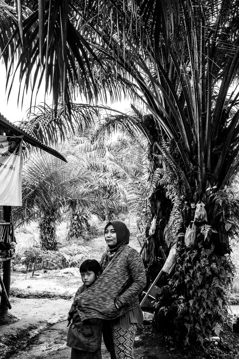 Asnia (right) and her only daughter, 6-year-old Dewi, who cannot hear or speak. Image by Xya Cruz Bacani. Indonesia, 2018.