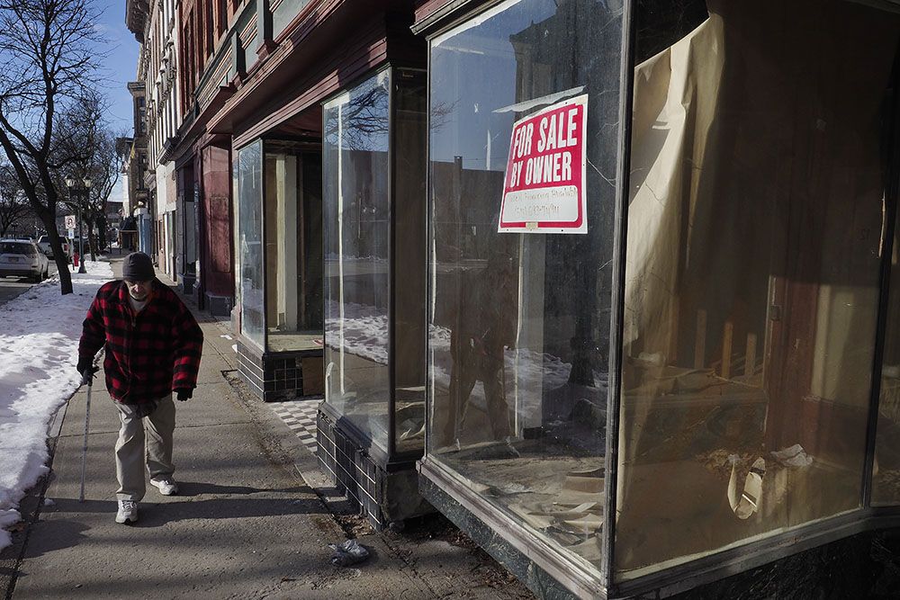 Ronald Ferrara, 73, walks past a row of vacant buildings along Gloversville’s Main Street. Ferrara worked in the tannery industry as a young man and said he quit after suffering health effects from chemical exposure. Image by Larry C. Price. United States, 2016.