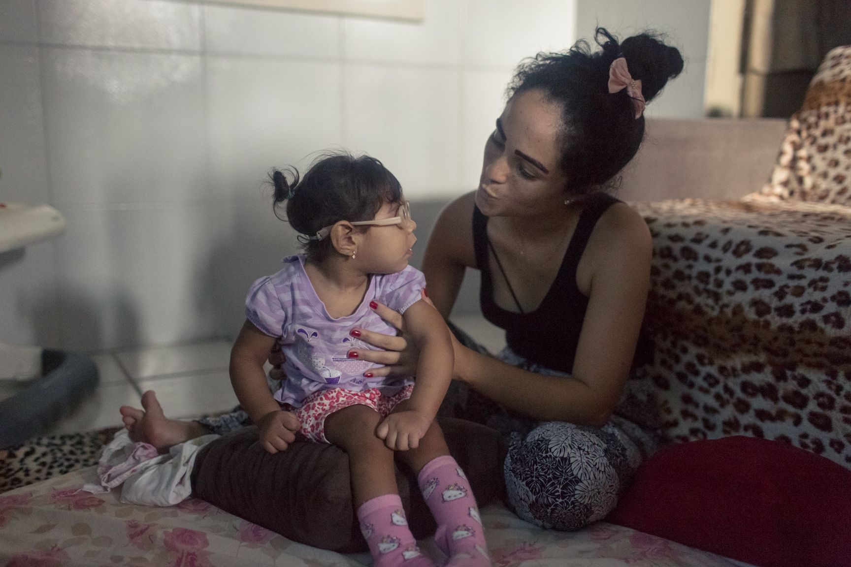 Mother and child: Dhulha Alen Silva do Nascimento and her daughter, Valentina, share a quiet moment at home. Image by Fábio Erdos. Brazil, 2017.