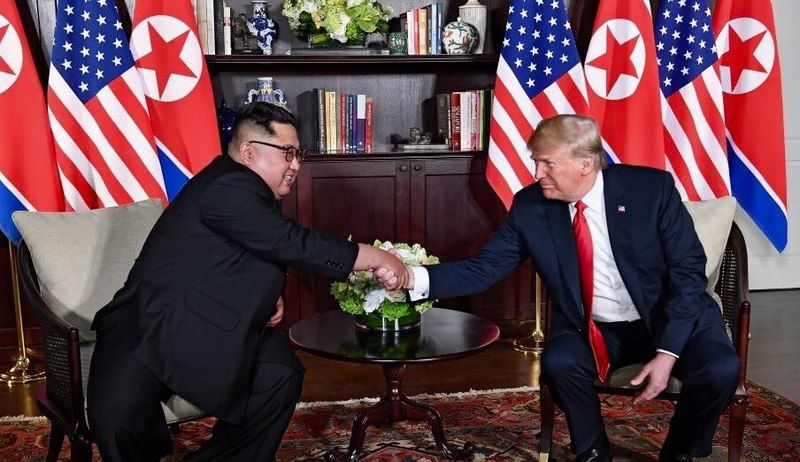 Trump and Kim shaking hands in the summit room during the DPRK-USA Singapore Summit. Image by Shealah Craighead/Wikimedia Commons. Singapore, 2018.