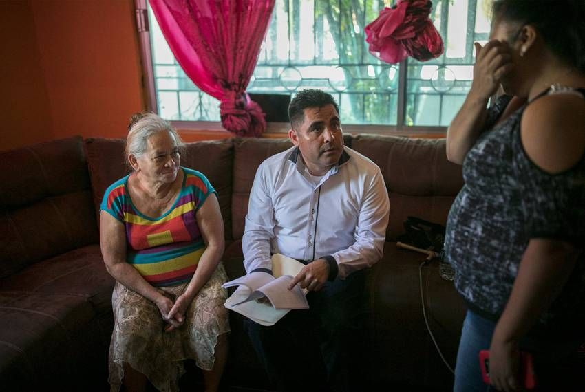 Immigration lawyer Eduardo Beckett sits next to his client, Bertha Arias, as he speaks to Elena, the owner of the safe house where Arias stays in Ciudad Juárez. Image by Ivan Pierre Aguirre. Mexico, 2019.