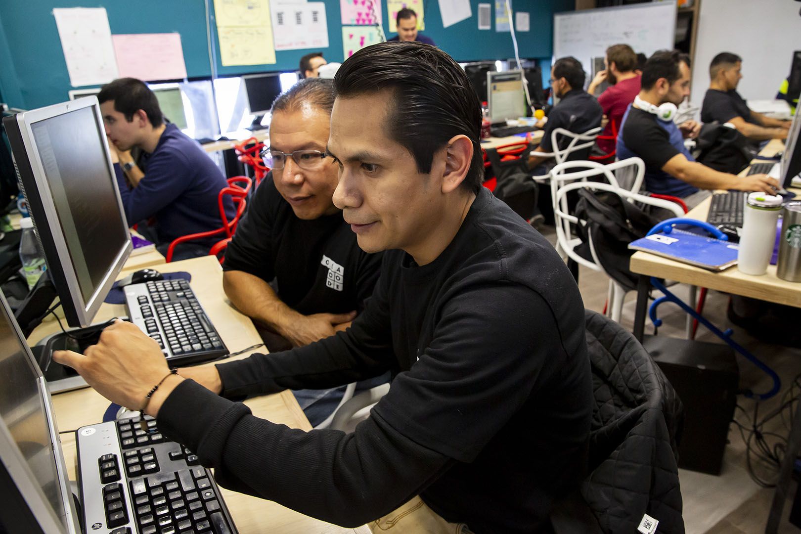 Orlando Mendoza works during classes of Hola Code, a nonprofit that offers training in software development for returnees and deportees in Mexico. Mendoza recently graduated from the program and secured a job. He grew up in Yakima and the Seattle area. Image by Erika Schultz. Mexico, 2019.