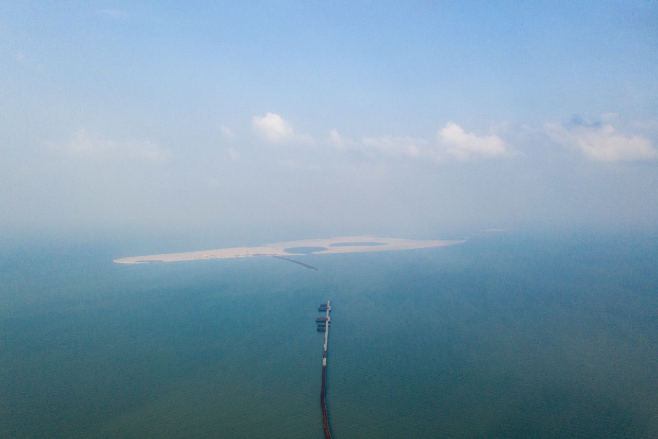 Ruyi island, off Haikou city, was intended as a tourist destination, with theme parks and hotels. Its planned size is over 7 square kilometres and it is to be linked to the mainland through a 5.6 km bridge. In an inspection by the authorities in 2017, the project was found to have reclaimed 210,000 sqm of the sea without proper permits. The land reclamation there which started in 2015 has been stopped because of both the environmental inspection as well as the developer running short of funds. In July 2018, Kaisa, another developer has bought the whole Ruyi Island project from its original developer Zhonghong at 1.4 billion rmb. Florida-based landscape architecture company EDSA is listed as being involved in the project. The Dubai of China in recent years, China’s coastal provinces—which house most of the country’s population—have been reclaiming land at a rapid pace, artificially creating huge tracts of land where seas, mangrove and wetland once were. Among the fastest-urbanising countries in the world, China has no shortage of useable land, but land reclamation has become seen as a quick and cheap way to get “a blank slate” of land to build on. Reclaimed land usually costs between $310,000 and $670,000 per hectare. If you compare this cost to the average cost of purchasing land (especially for commercial/residential purposes) in a big city, it’s in some locations at least 10 times more expensive to buy land, than to reclaim. Since 2006, 13,000 hectares of land (32,123 acres) have been reclaimed on average each year, swallowing up beaches, islands and wetlands. Mangroves which protect the coast and migratory birds’ habitats have been wiped out.Alarmed by this and its impact on the marine ecosystem, China’s government in January and July last year (2018) slapped a ban on commercial land reclamation. Image by Sim Chi Yin. China, 2018.