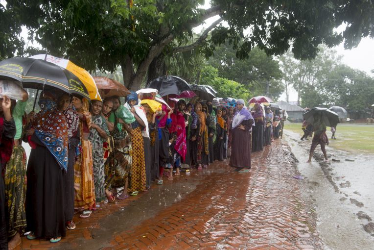 Women wait in line in the rain to collect 20kg bags of rice that is given out by the government as part of a VGF (Vulnerable Group Feeding) program ahead of Eid-ul-fitr in a southwestern village of the country. Image by Nikita Sampath. Bangladesh, 2016.