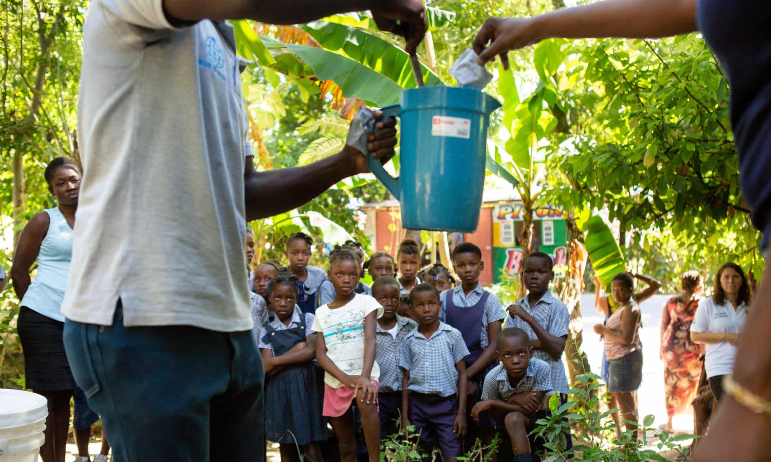 School children near Mirebalais are shown how to mix oral rehydration solution as part of an effort to head off any recurrence of cholera in Haiti. Image by Allison Shelley. Haiti, 2020.