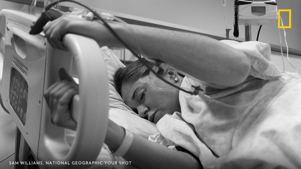 12 hours into an eventual 17-hour childbirth, my girlfriend was definitely feeling the pain. I looked on helplessly as nothing compared to the moments of pain and the respite between. Gas, drugs, and a hand to hold only had so much effect. This day I found out how truly strong she is… Image by Sam Williams, National Geographic Your Shot.