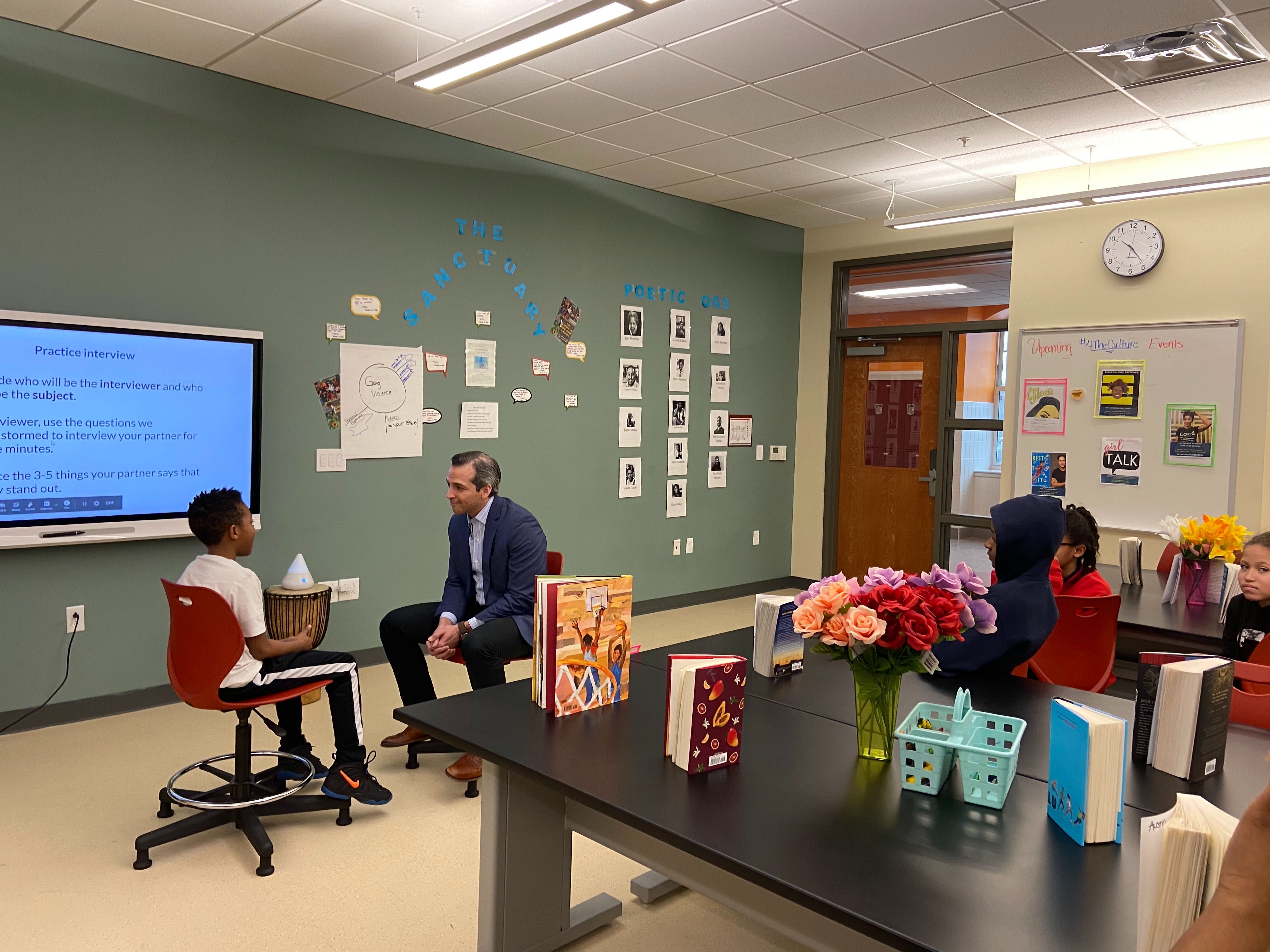 PBS NewsHour special correspondent Nick Schifrin works with a student during the post-field trip workshop at Ida B. Wells Middle School. Image by Pauline Werner. United States, 2020.