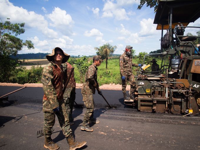 Soldiers pave some of the last miles of BR-163, a highway cutting through the Amazon basin which Bolsonaro had pledged to complete. For years, trucks carrying grain for export have lumbered along this slow, muddy road. Its completion significantly reduces transport time. Image by Heriberto Araújo. Brazil, 2019.