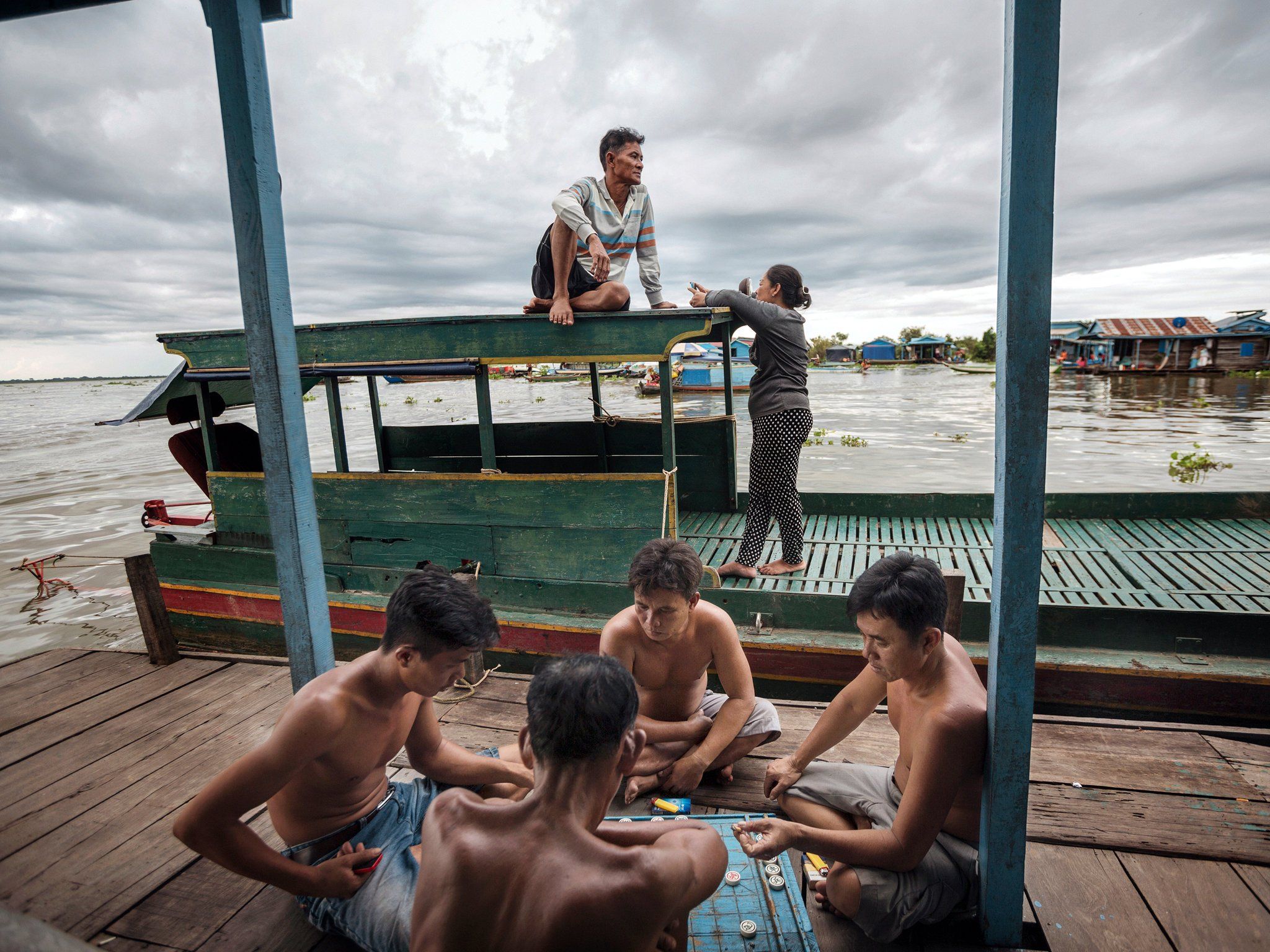 Playing xiangqi on the porch of a floating house in the village of Chhnok Trou. Image by Andrea Frazzetta. Cambodia, 2018.