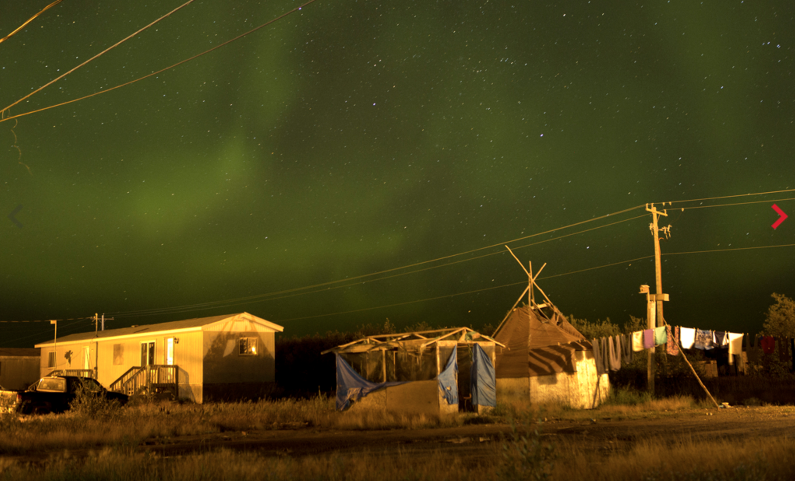 The northern lights fill the sky over the remote First Nations community of Attawapiskat. Attawapiskat is an isolated First Nation community located in northern Ontario, Canada, at the mouth of the Attawapiskat River on James Bay. On April 9, 2016, the community of approximately 2000 people declared a state of emergency after being overwhelmed with attempted suicides, over 100 attempts in a ten month period. Image by David Maurice Smith/Oculi. Canada, 2016.