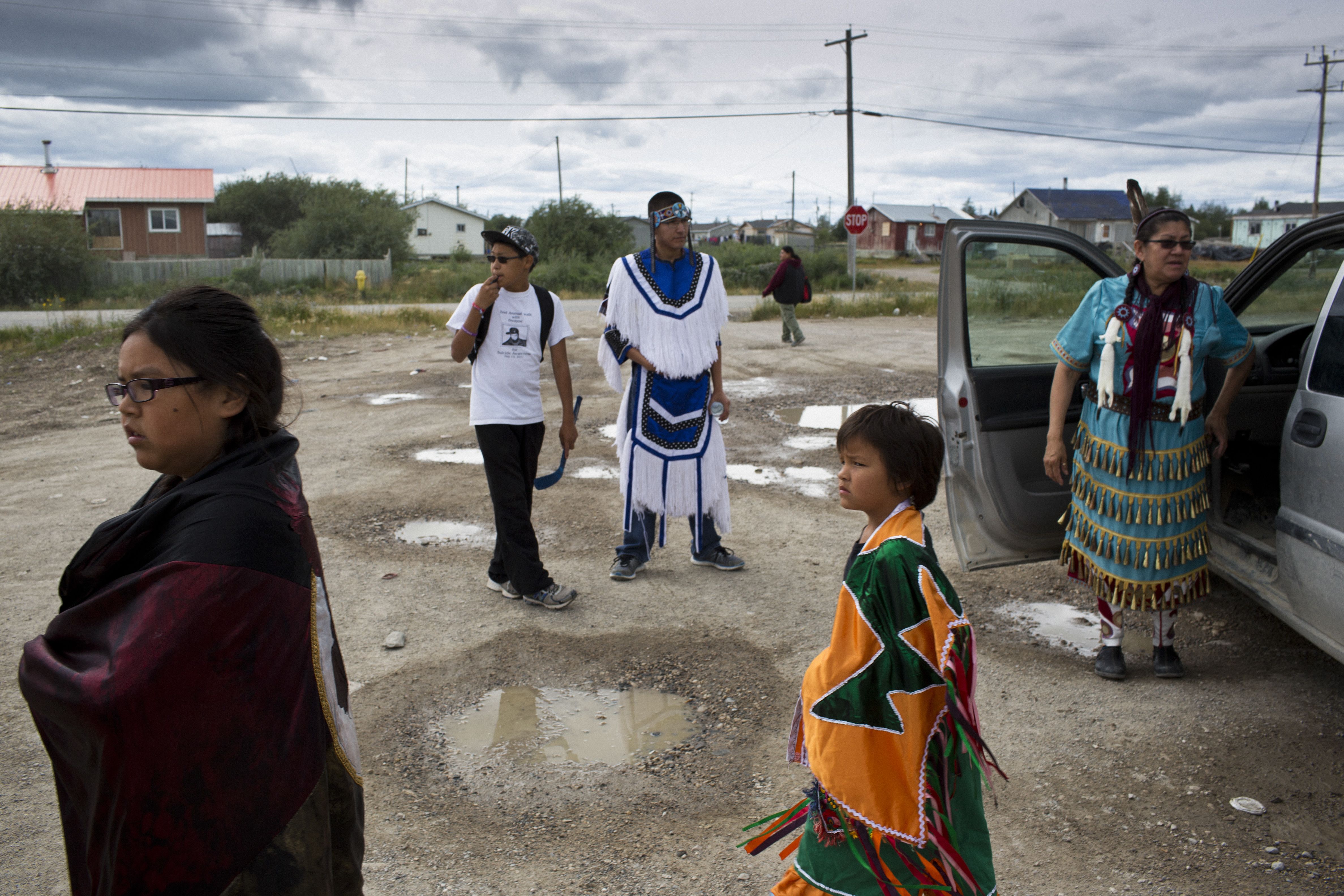 Pow Wow dancers gather outisde the Reg Louttit Arena in Attawapiskat after a practice. For many in the community, a return to traditional practices offers a hope for healing and connection and a way of navigating the challenges their people face. While the Canadian government is seen to be failing First Nations people by many in Attawapiskat, the community continues to approach the complex issues themselves. Image by David Maurice Smith. Canada, 2016.
