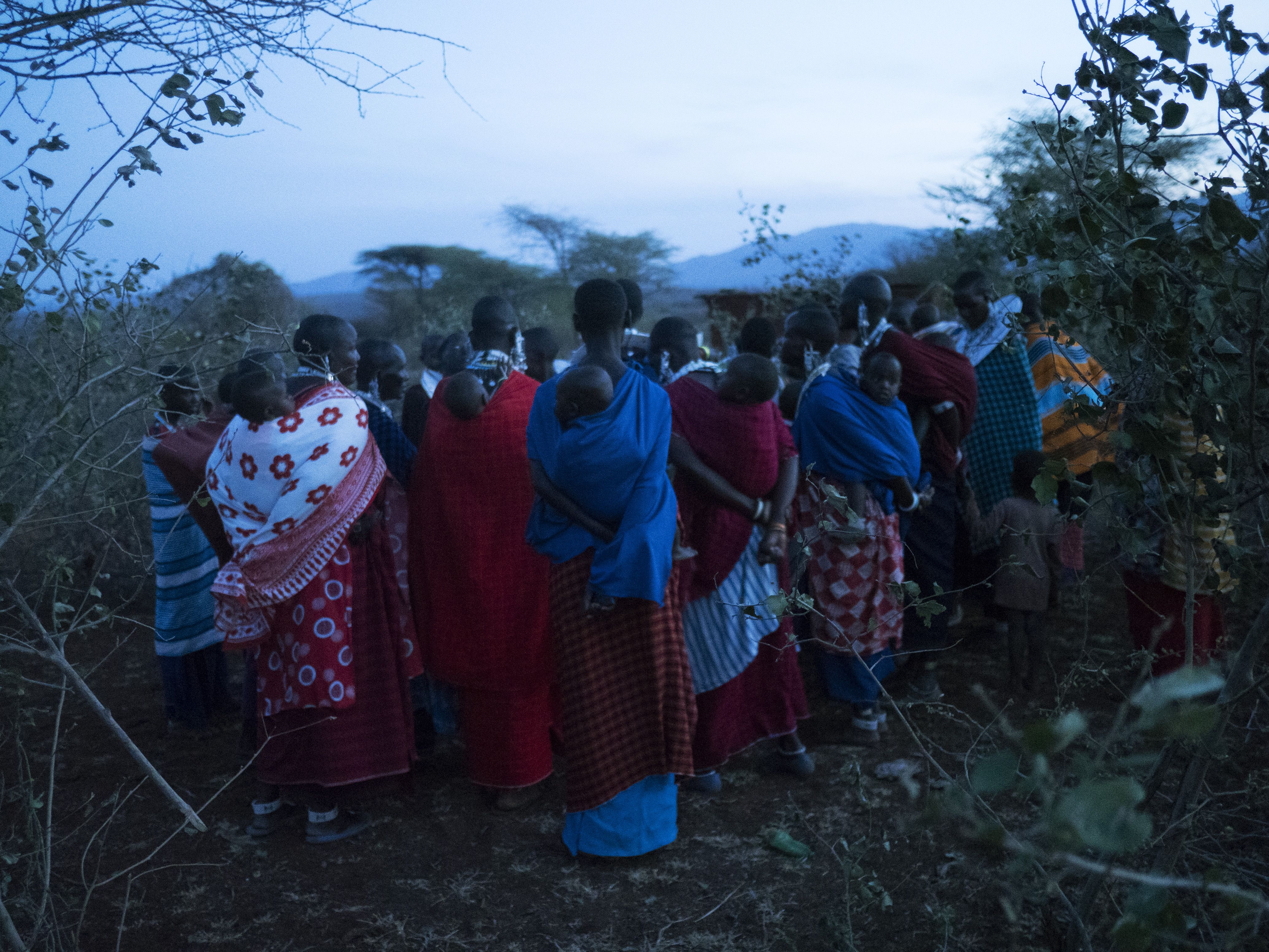 Maasai women preparing the slaughtering of a sheep to ask for rain. A recent drought and the dislocation of their traditional grazing land has created difficulties. Image by Thomas Dworzak/Magnum Photos. Tanzania, 2018.