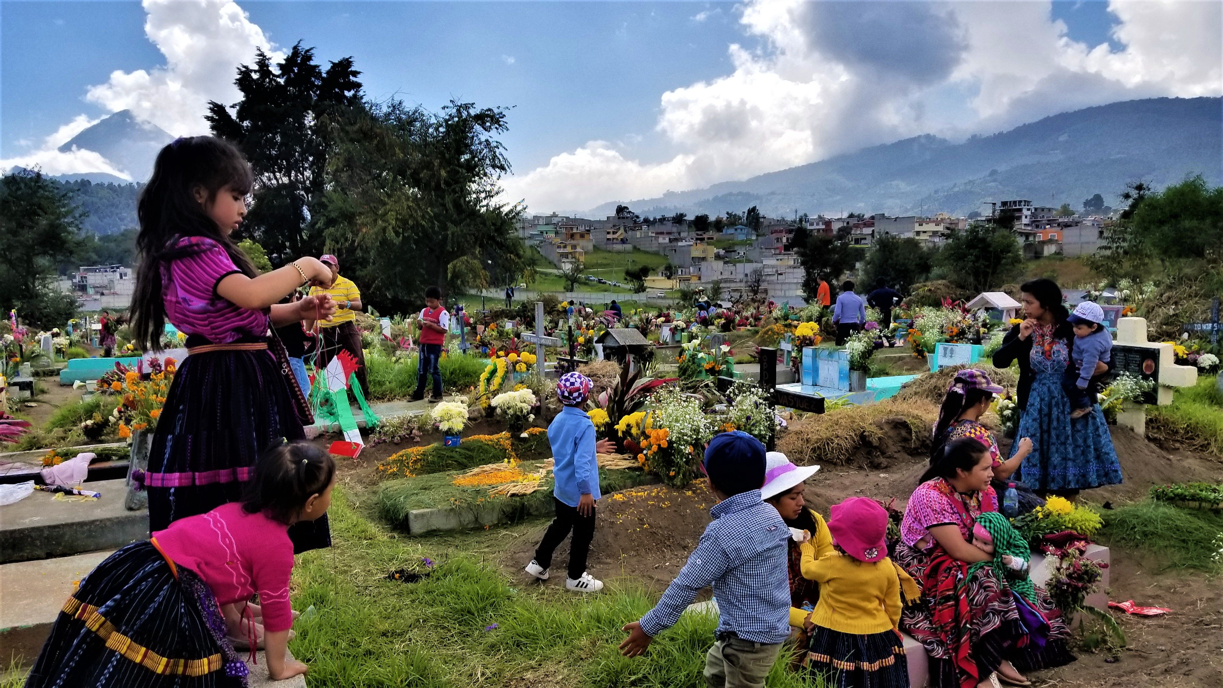 Local cemeteries come to life when families decorate the graves of their loved ones with candles, fresh cut grass, and flowers. For two days they pray, eat, and remember their ancestors in honor of Day of the Dead. Image by Kristian Hernandez. Guatemala, 2018.