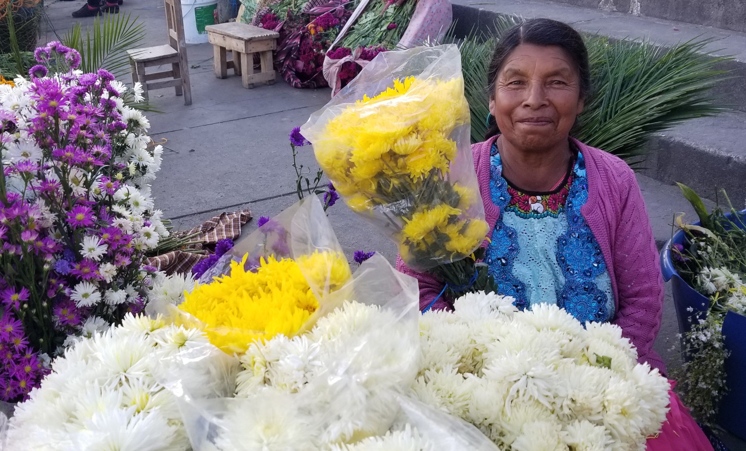 A vendor sells flowers outside El Calvario Cemetery. Image by Kristian Hernandez. Guatemala, 2018.