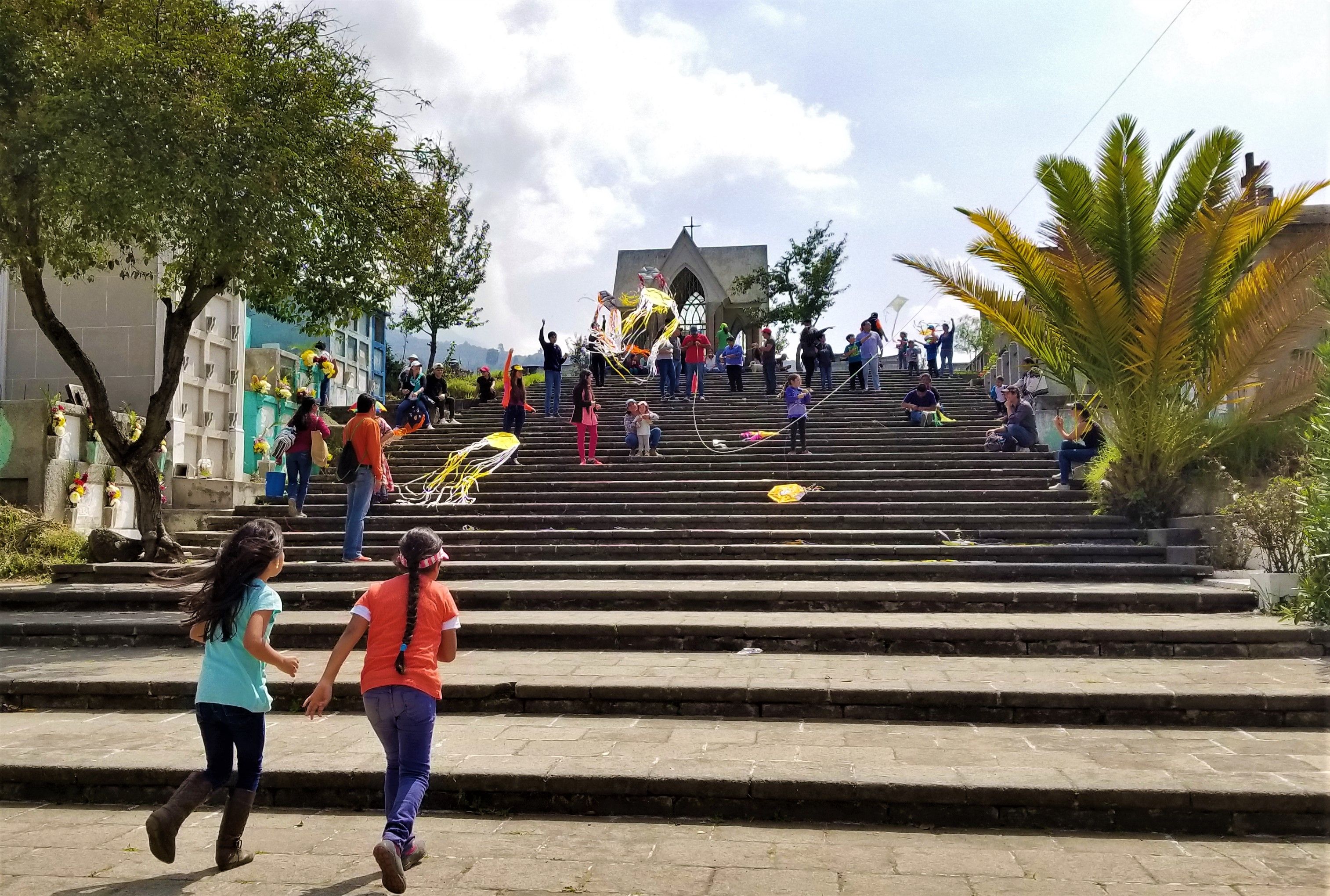 It is tradition for children to fly barriletes or kites atop the gravesites on Day of the Dead. Locals believe it helps the souls of those trapped in purgatory to ascend to the heavens. Image by Kristian Hernandez. Guatemala, 2018.