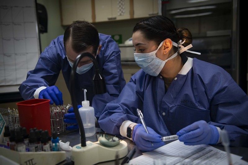 U.S. Navy Hospital Corpsman 3rd Class Janet Rosas (right,) and Hospital Corpsman 2nd Class Cecil Dorse test blood samples aboard the Military Sealift Command hospital ship USNS Comfort in New York City. Image courtesy of U.S. Navy Mass Communication Specialist 2nd Class Sara Eshleman. United States, 2020.