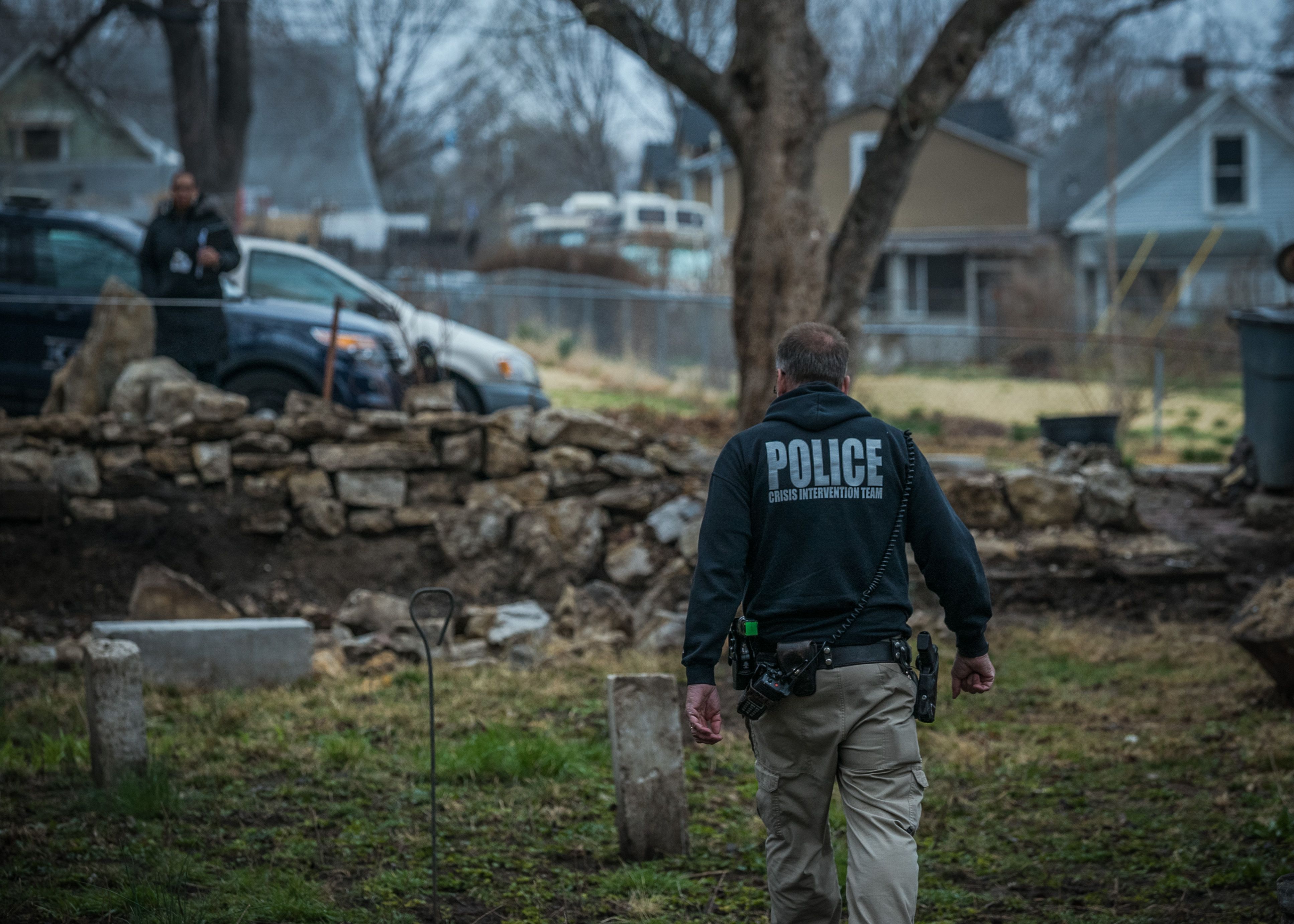 Kansas City, MO Police Officer Aric Anderson, who is part of the police crisis intervention team, looks for a homeless man with mental illness at an abandoned house he is known to stay at. Image by PBS Newshour. United States, 2018.