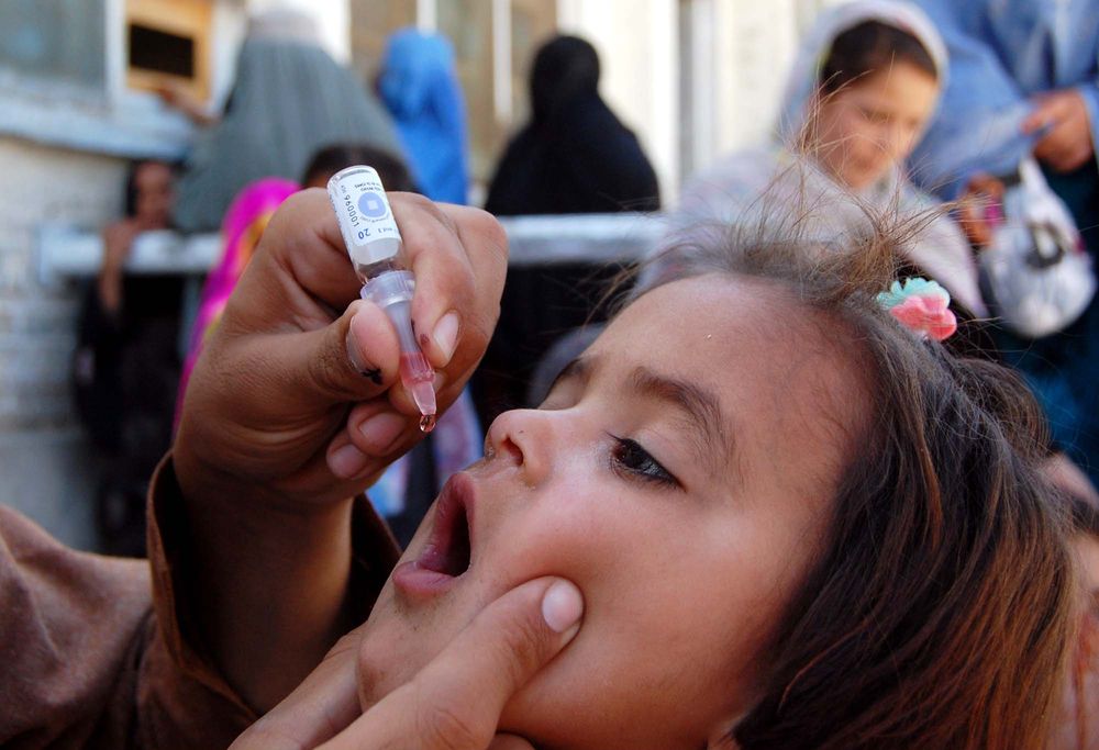 Health worker administrates polio-vaccine drops to a child during anti-polio immunization campaign at Pak-Afghan Border on April 08, 2015 in Chaman. Image by Shutterstock. Pakistan, 2015.