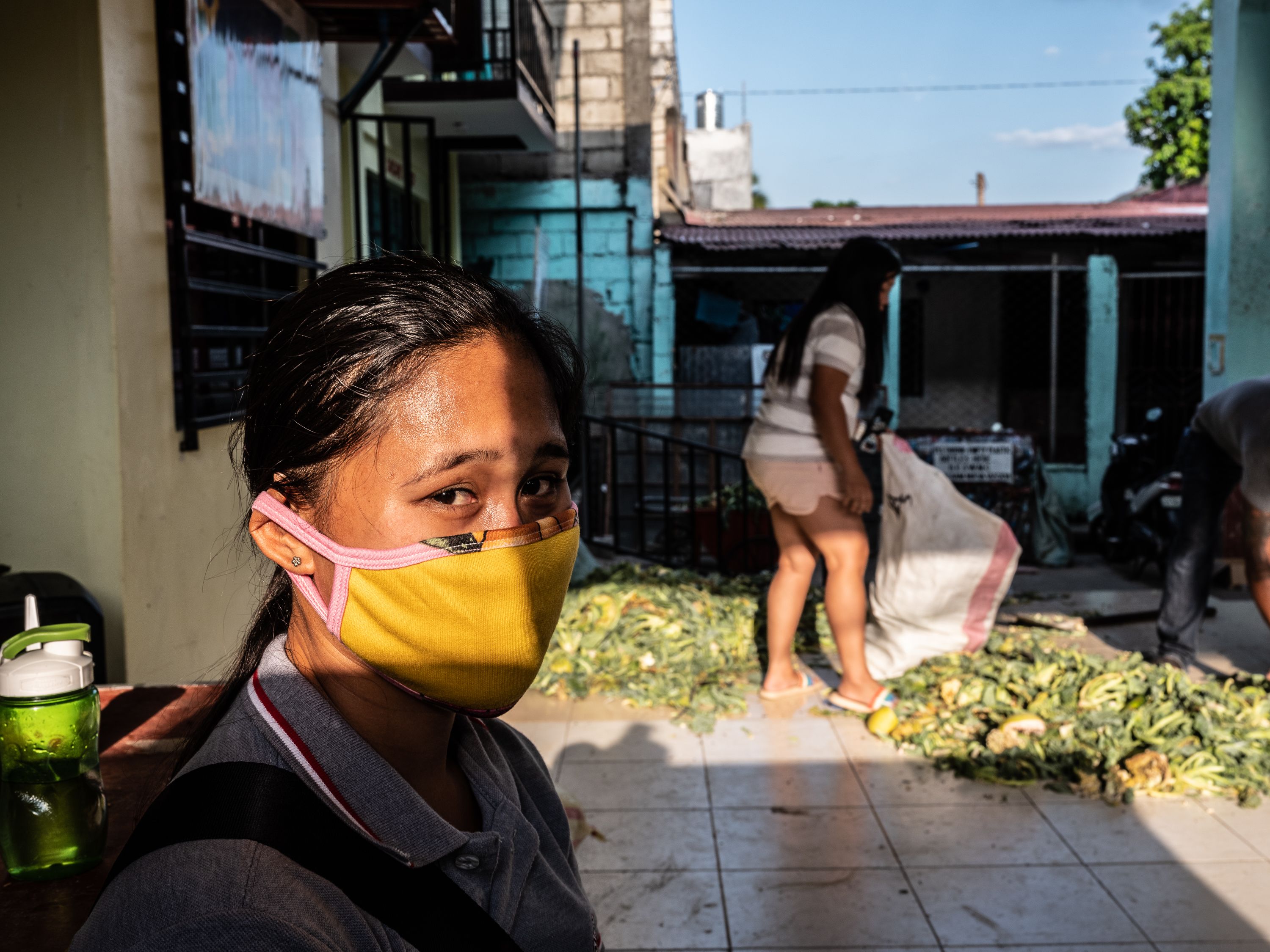 Analyn Martinez, a volunteer health care worker, rests after her shift, which includes checking in on quarantined people and packing and distributing relief goods. Image by Xyza Bacani. Philippines, 2020.