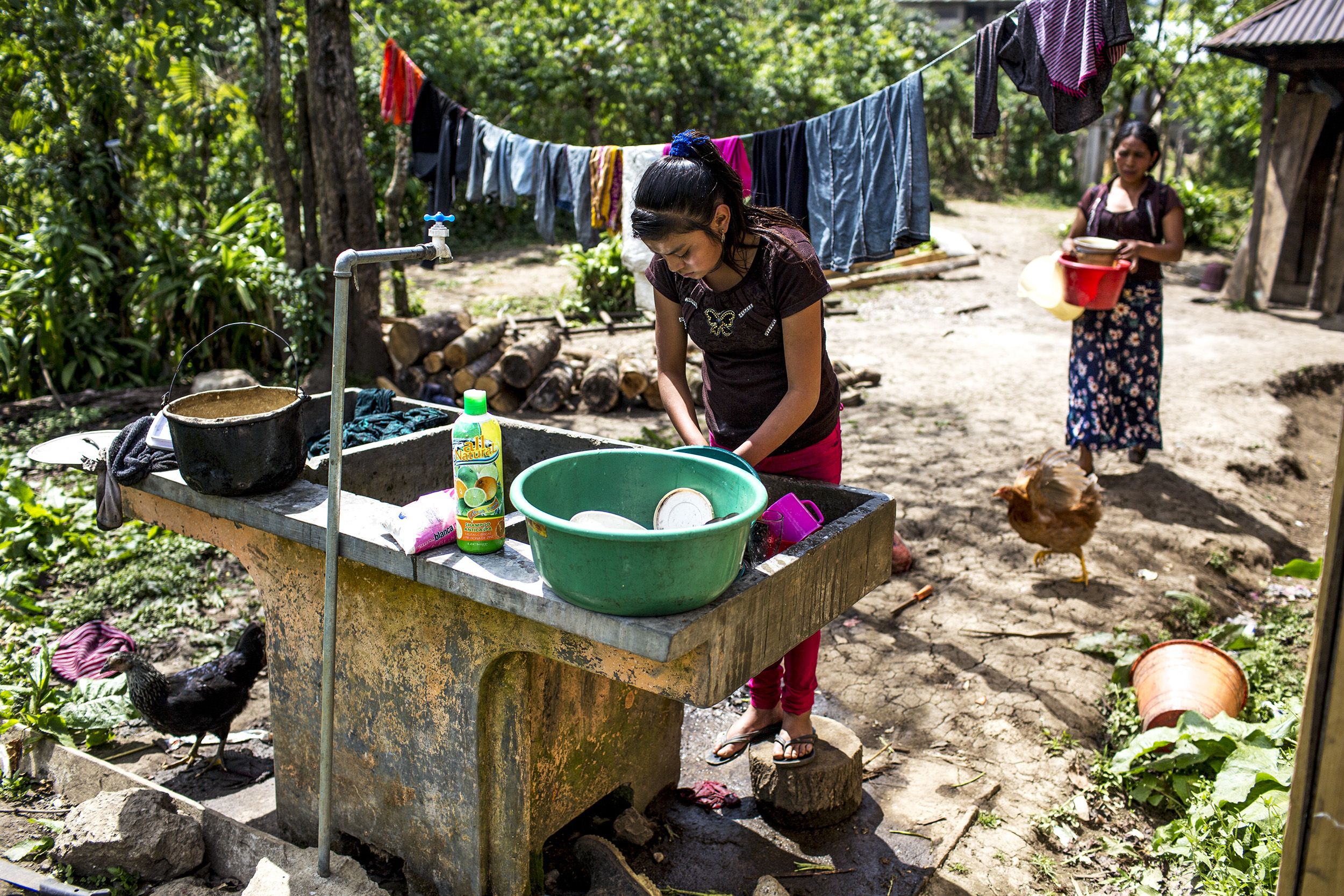 Candelaria López, 15, washes dishes in her front yard in Bulej. Image by Simone Dalmasso/Arizona Daily Star. Guatemala, 2019.
