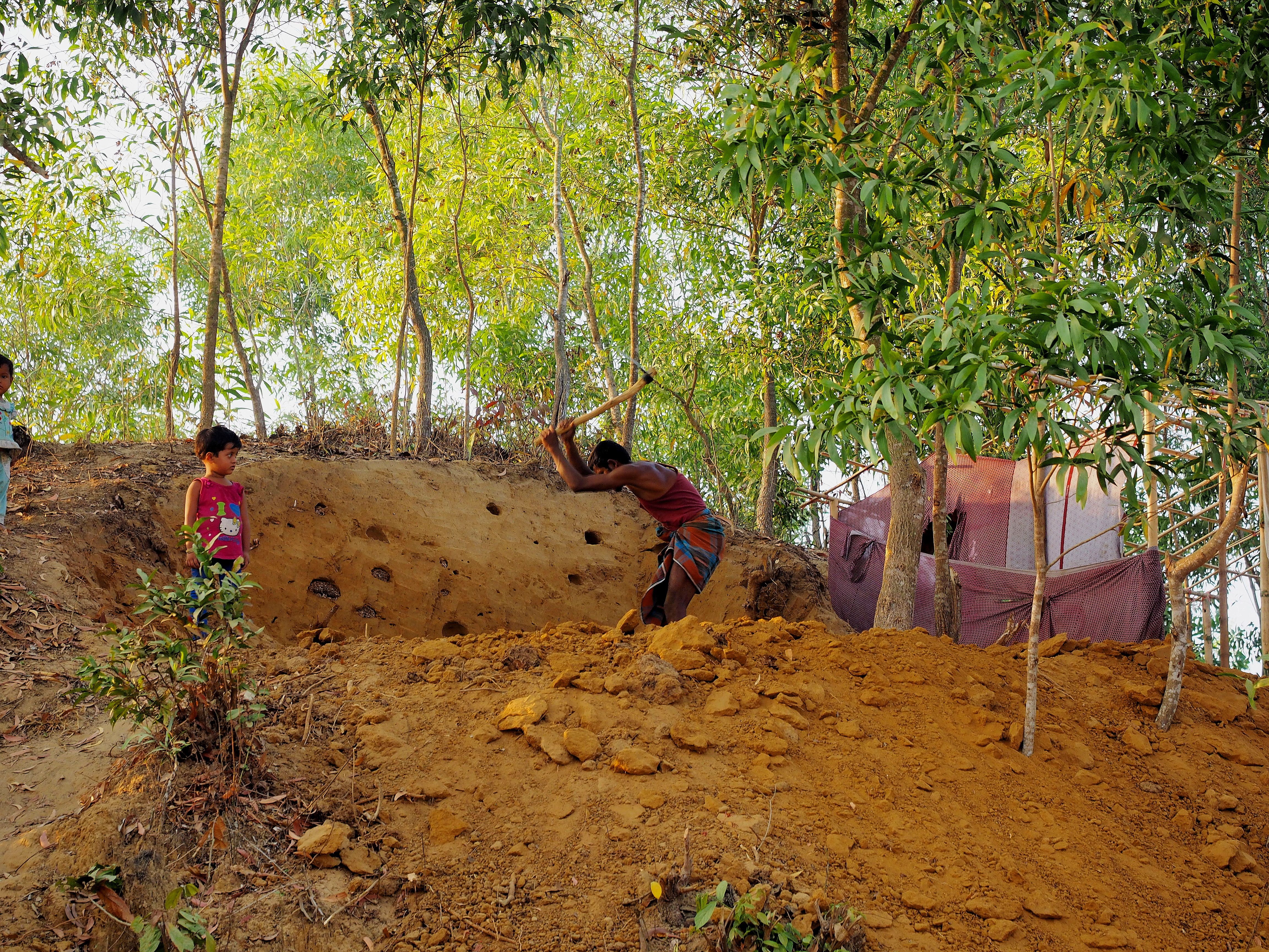 Rohingya refugee digging foundation for new house in squatter refugee camp. Image by Doug Bock Clark. Bangladesh, 2017.